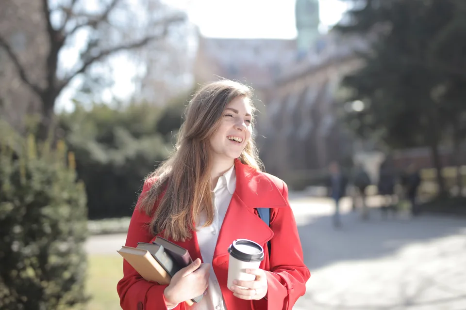 Étudiante sur un campus, livres en main