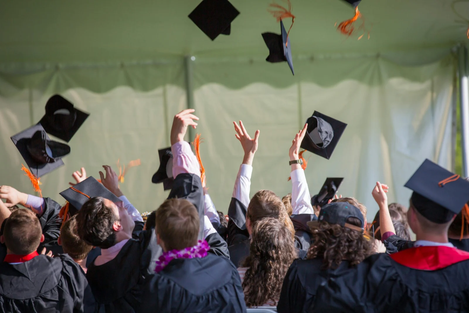 Des diplômés lancent leurs toques lors d’une cérémonie