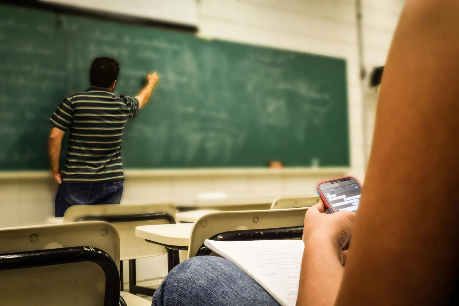 Un enseignant écrit au tableau pendant un cours
